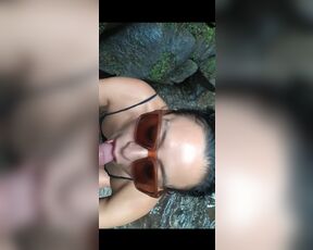 Sexy Latin girl in sunglasses sucking by crowded waterfall